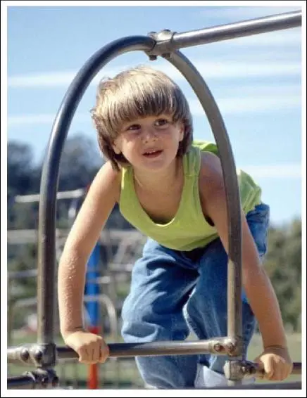 A young boy is playing on the playground.